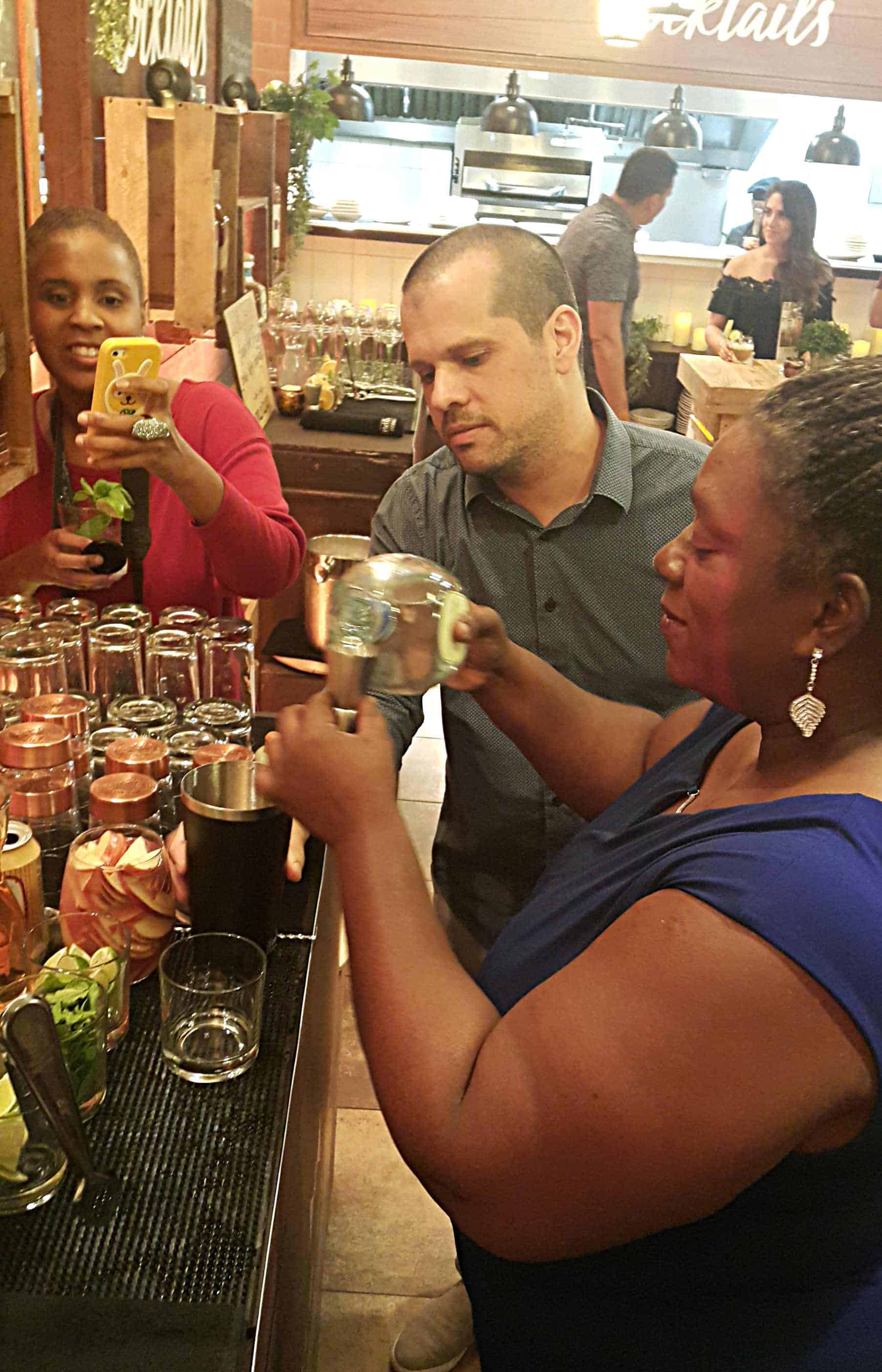 Rafael Reyes looks on a Laura Dowrich-Phillips tries her hand at making a cocktail